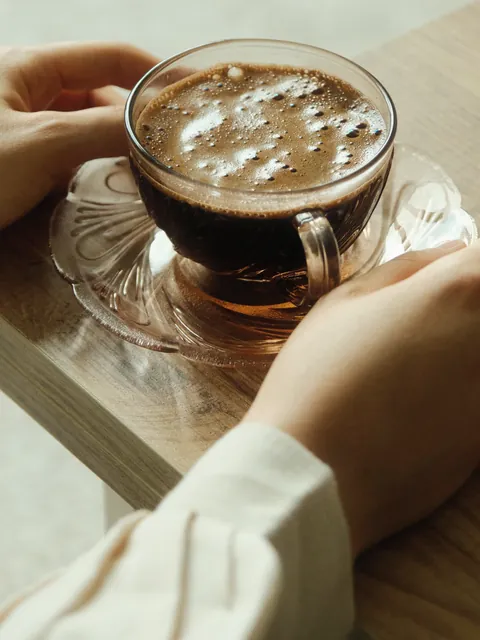 光の中でグラスを持つ手
